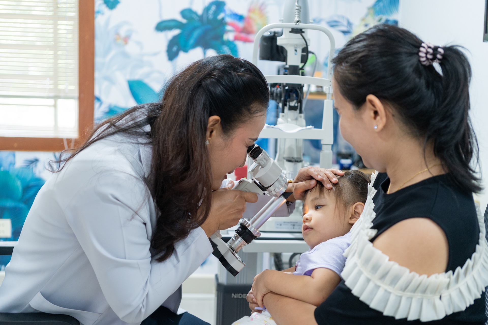 Doctor examining newborn baby's eyes